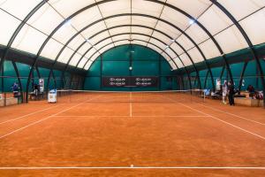 an indoor tennis court with a tennis court net at Hotel Kortowo in Poznań