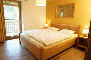 um quarto com uma cama num quarto com uma janela em ecoHouse FURLAN - Apartment PINJA em Kobarid