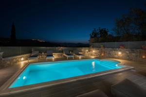 a swimming pool in a backyard at night with lights at Kanathos Pigi in Nafplio