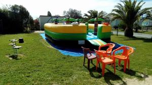 un parque de juegos con un barco inflable en el césped en Camping Cap Soleil, en Saint-Denis-dʼOléron