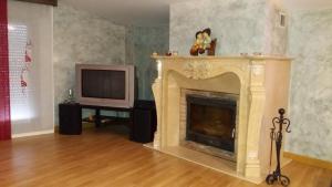 a living room with a fireplace and a television at Hotel Brezales in Espejón
