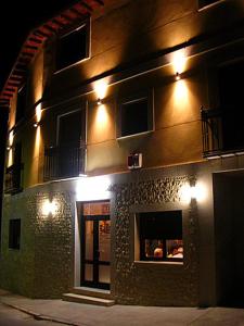 a building with lights on the side of it at night at Hotel Brezales in Espejón