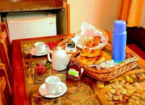 a table topped with cups and a basket of pastries at Lahuen-co Paraje de Mar in Valeria del Mar