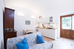 a living room with a blue couch and a kitchen at La Scivitella in Amalfi