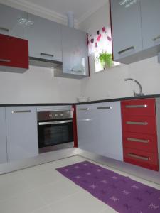 a kitchen with red and white cabinets and a purple rug at Alojamento Cesarini in Montijo