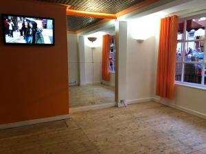 a room with a television on the wall and a hallway at Coco Beach Hotel in Blackpool