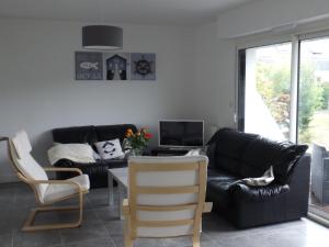 フエナンにあるVilla proche plagesのリビングルーム(黒い革張りのソファ、椅子付)