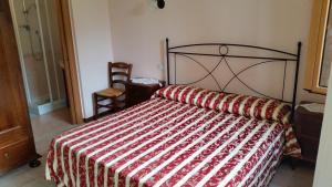 una camera con un letto e un piumone rosso e bianco di B&B La Tenuta del Conte a Fermo