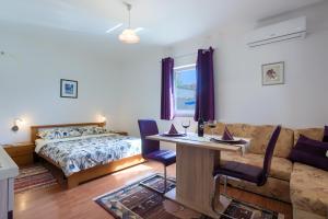 - une chambre avec un lit, une table et un canapé dans l'établissement Apartment Monica, à Ližnjan