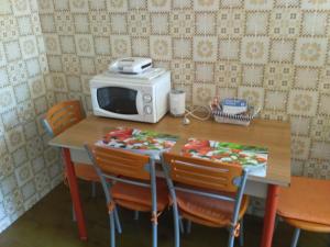 einen Tisch mit Stühlen und eine Mikrowelle darüber in der Unterkunft Appartamenti Menapace in Torri del Benaco