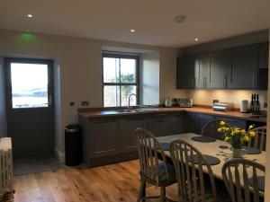 a kitchen with a table and chairs and a sink at Dunvegan Castle Keepers Cottage in Dunvegan