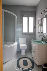 a bathroom with a tub and a toilet and a sink at Ionion Star Hotel in Preveza