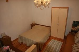 a small bedroom with a bed and a chandelier at Apartments Imperial in Dubrovnik