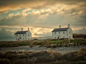 two white houses on the shore of a beach at Conwy Cottage in Conwy