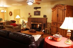 een woonkamer met een bank en een open haard bij Adair Springs Cabin in Pinetop-Lakeside