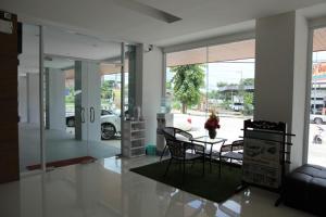 uma sala de jantar com uma mesa e cadeiras num quarto em The Ocean Residence em Nakhon Ratchasima