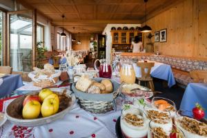 una mesa cubierta con cestas de pan y otros alimentos en Thalerhof Tiers en Tires