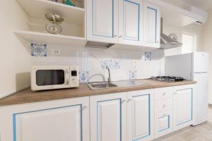 Lido ConchigliaにあるCasa Vacanze Anfitriteのキッチン(青と白のキャビネット、電子レンジ付)