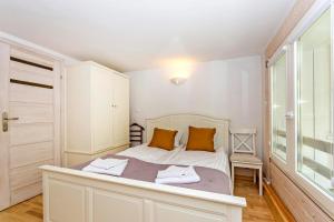ソポトにあるCarlo Rentyear Apartmentsのベッドルーム1室(白いベッド1台、オレンジ色の枕付)