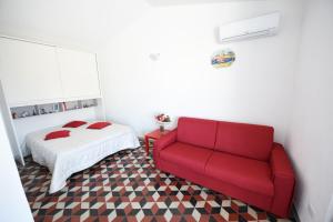 カステッランマーレ・デル・ゴルフォにあるTerrazza in Palazzo Taorminaのベッドルーム(赤いソファ、ベッド付)