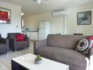 a living room with a couch and a kitchen at Jadran Motel & El Jays Holiday Lodge in Gold Coast
