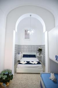 a bedroom with a bed in a white room at Palazzo Taormina in Castellammare del Golfo