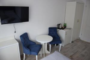 a small room with a table and two blue chairs at Remiza w Starej Papierni in Łapino