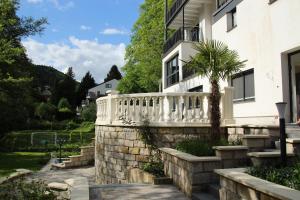 una casa bianca con un muro in pietra e una palma di holidayhome Heidelberg a Heidelberg