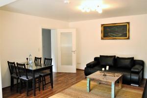 a living room with a black couch and a table at holidayhome Heidelberg in Heidelberg
