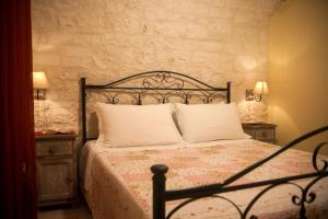 a bedroom with a bed with two night stands and two lamps at Il Calàscione Apulian Villas in Locorotondo