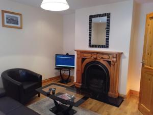 uma sala de estar com lareira e televisão em Townhouse 4 Barrow Lane em Carlow
