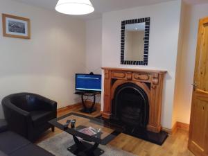 sala de estar con chimenea y TV en Townhouse 4 Barrow Lane, en Carlow