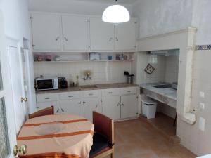 a kitchen with white cabinets and a table and a microwave at 100% Lisbon in Lisbon