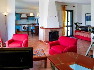 ポリカストロ・ブッセンティーノにあるCasa Alberico - Golfo di Policastroのリビングルーム(赤い椅子、暖炉付)