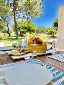 a picnic table with a basket of fruit on it at Soltroia lake Dream house in Troia