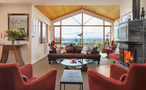a living room with a couch and a fireplace at Chalet Eiger in Taupo