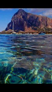 a large body of water with a mountain in the background at La Rosa Blu in San Vito lo Capo