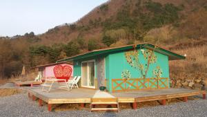 a small house with a wooden porch and a deck at Pyeongchang Healing Stay in Pyeongchang