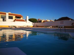 a swimming pool with blue water in front of a building at Sonder in Caleta De Fuste