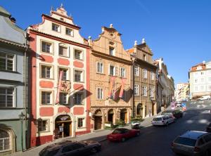 een stadsstraat met auto's geparkeerd voor gebouwen bij Red Lion Hotel in Praag
