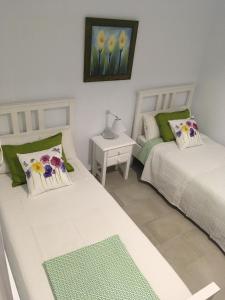 a bedroom with two beds and a table with a lamp at Sonder in Caleta De Fuste +32 photos