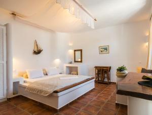 a bedroom with a white bed and white walls at Giannoulis Hotel in Adamantas