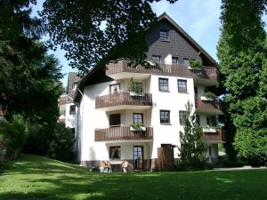 un gran edificio blanco con balcones en el césped en Bocksbergblick Fewo Auszeit, en Goslar