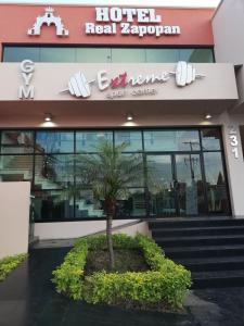 a hotel with a palm tree in front of a building at Hotel Real Zapopan in Guadalajara