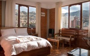 a bedroom with a bed with a view of a city at Qhini Hotel Boutique in La Paz