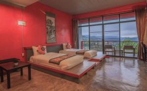 two beds in a room with red walls at Wang Put Tan Boutique House in Mae Salong