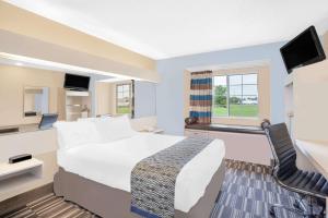 ein Hotelzimmer mit einem großen Bett und einem TV in der Unterkunft Microtel Inn and Suites Clear Lake in Clear Lake
