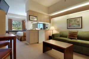 a small living room with a couch and a kitchen at Microtel Inn & Suites by Wyndham Bloomington MSP Airport in Bloomington