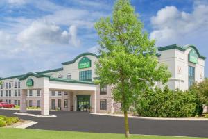 a large white building with a tree in front at Wingate by Wyndham Green Bay in Green Bay