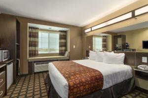 a hotel room with two beds and a television at Microtel Inn & Suites by Wyndham Minot in Minot